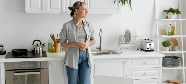 Woman standing in tidy stylish kitchen