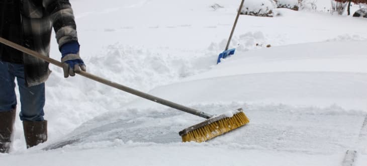 man using brush to sweep decking