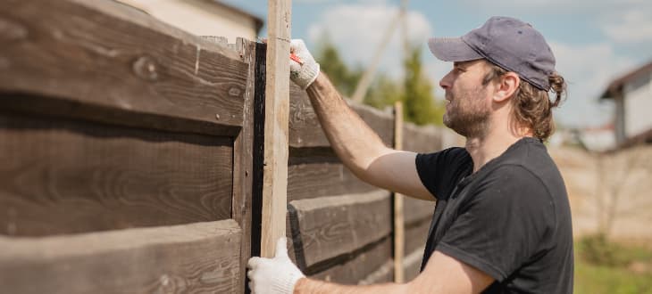 man rebuilding fence