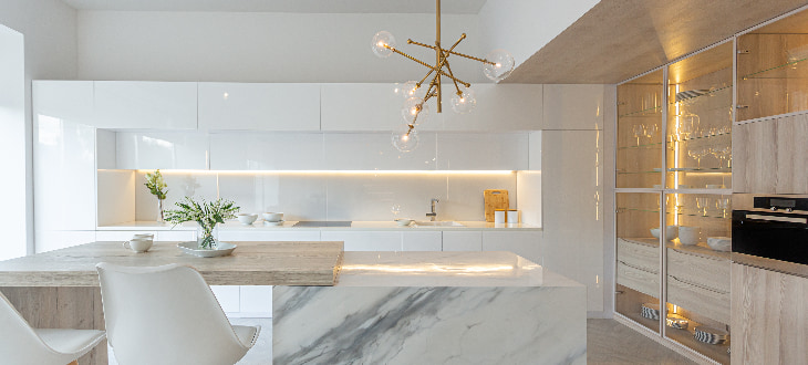 marble, modern kitchen illuminated by warm lights in and under cabinets