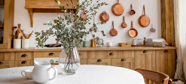 rustic kitchen with teapots, pans and flowers neatly arranged