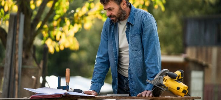 man planning and measuring garden decking