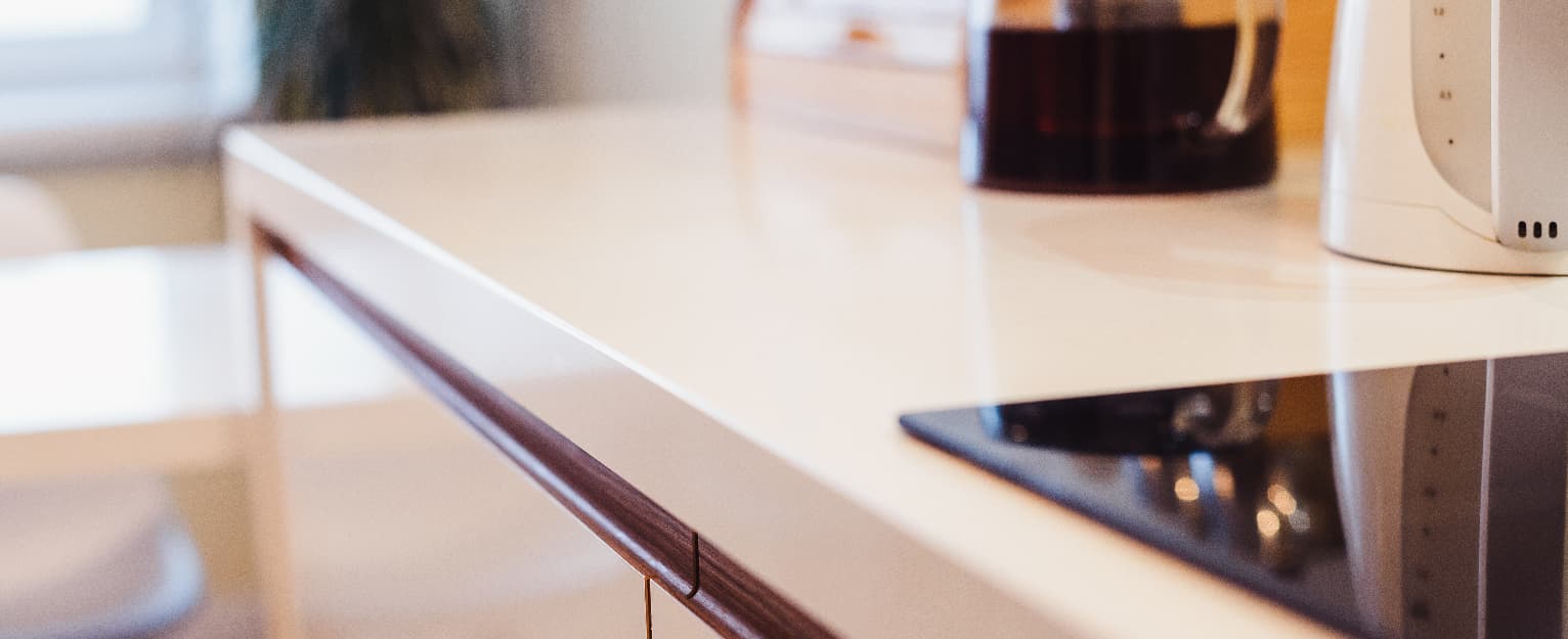 Close-up of a modern kitchen worktop with a sleek edge profile and integrated cabinetry detail