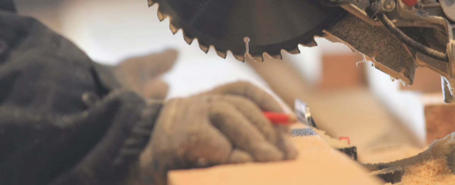 Close-up of a tradesperson cutting timber with a circular saw in a workshop, demonstrating precision woodworking and timber preparation for construction or DIY projects.